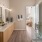 Luxury Apartments near Army Airfield in Savannah, GA - Aventon Victory - Spa-Like Bathroom with a Double Vanity, Wood-Inspired Plank Flooring, Two Mirrors, A Glass Shower, and Accent Pendant Lighting