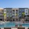 Dog-Friendly Luxury Apartments in Savannah, GA - Aventon Victory - Resort-Style Pool with Saltwater, with Sun Shelf, Umbrellas with Table and Chairs Surrounded by Tanning Lounge Chairs with Palm Trees